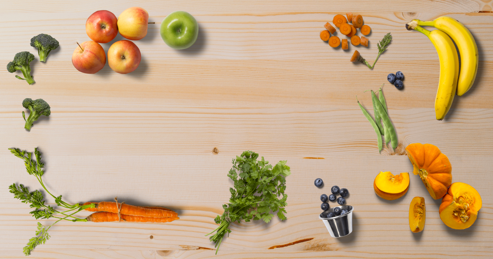 Fruit and vegetables on a table, showing the variety of ingredients in the dog food.